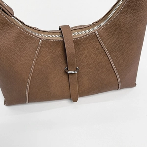 Detail of brown lychee grain leather hobo bag with white contrast stitching and D-ring
