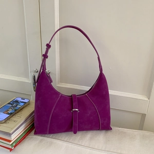 Close-up of deep purple leather underarm bag with white contrast stitching and soft texture