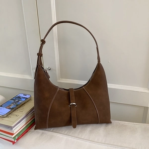 Detail of retro dark brown suede hobo bag with contrast stitching and metal buckle