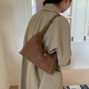 Brown leather crescent underarm bag with contrast stitching and vintage metal buckle