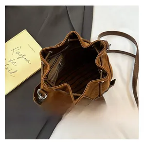 Detailed interior view of brown suede bucket bag with striped lining and zipper pocket