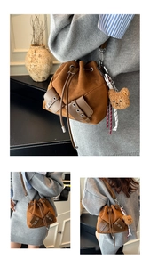 Macro detail of brown suede bucket bag with leather patches and plush bear charm
