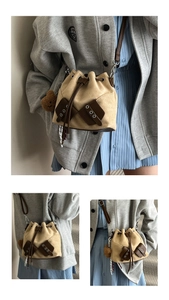Detail of beige drawstring bucket bag with brown decorative buckles and small bear charm