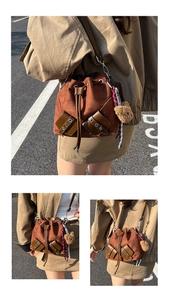 Detail of brown suede bucket bag featuring drawstring closure and a cute plush bear pendant