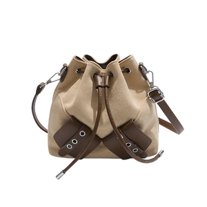 Chic khaki faux suede bucket bag with dark brown leather trim and adjustable strap
