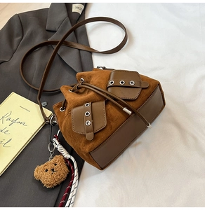 Detailed top view of caramel suede bucket bag with drawstring and cute bear charm