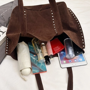 Large dark brown suede tote bag with vintage metal rivets showing spacious interior capacity