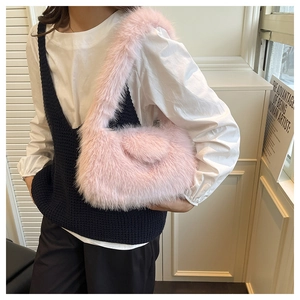 Close-up of light pink plush faux fur shoulder bag worn by model over a white shirt