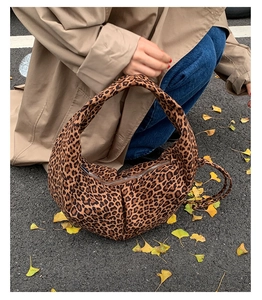 Gros plan détaillé d'un sac demi-lune imprimé léopard porté par un mannequin en automne