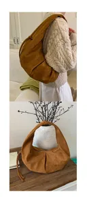 Détail du sac hobo en daim caramel avec design plissé et bandoulière à cordon