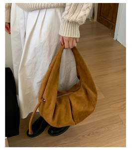 Gros plan détaillé du sac hobo en daim marron montrant la texture et le design plissé