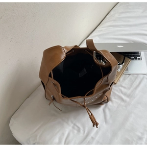 Internal view of brown leather bucket bag showing black lining and interior pocket