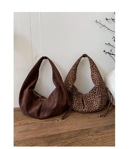 Détail de sacs hobo en faux daim marron foncé et imprimé léopard avec cordon de serrage