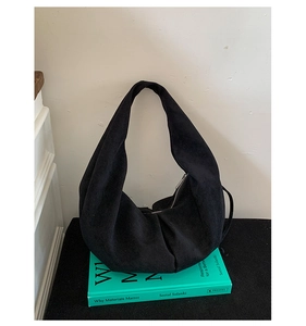 Détail de la texture douce et du design élégant plié du sac hobo en daim noir