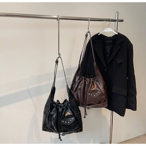 Close-up of vintage punk tote bags in black and brown with stud details and drawstrings