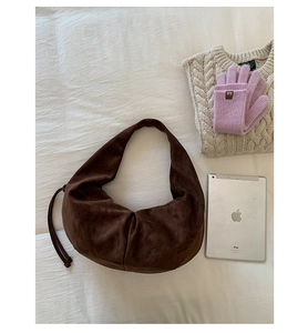 Détail du sac croissant en daim marron foncé avec cordon et maille d'automne douce