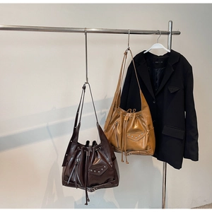 Detail of vintage punk bucket bags with metal rivets and drawstring in brown and yellow