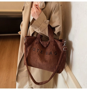Detail of corduroy tote bag with embroidered letters and wavy edges for retro style