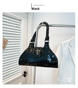 Close-up of black patent leather gothic handbag with silver cross and chain detail