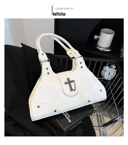 Detail of white patent leather handbag with gothic metal cross and silver studs in a cart