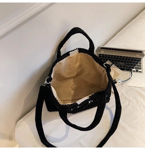 Detailed interior view of a black corduroy tote bag showing large capacity and lining