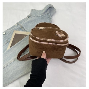 Dettaglio di un mini zaino in pelle scamosciata marrone con patch a stella e pelliccia