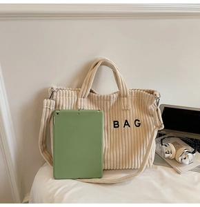 Detail of spacious beige corduroy tote bag showing interior space for a tablet and books