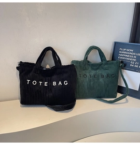 Detail of corduroy tote bags in black and dark green with textured embroidery