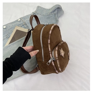 Dettaglio di mini zaino in pelle scamosciata marrone con stella e zip argentata