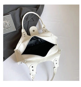 Top-down view of white leather tote bag with black lining and magnetic closure detail