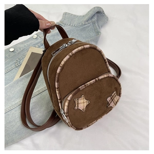Dettaglio mini zaino marrone con toppe a stella e bordo in peluche a quadretti vivaci