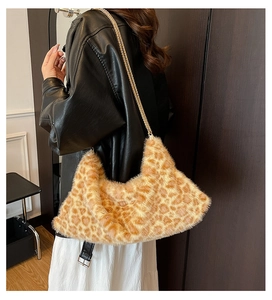 Détail d'un sac hobo en peluche léopard avec bandoulière chaîne dorée sur modèle