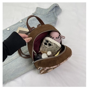 Dettagli interni di un mini zaino in pelle scamosciata marrone con fondo in peluche rosa