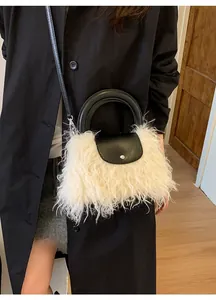 Chic plush faux fur handbag with black leather round handles shown on a model