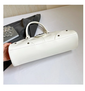 Detail view of white biker style handbag showing metal rivets and leather texture