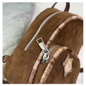 Dettaglio dello zaino vintage marrone con toppa a stella e bordo in peluche