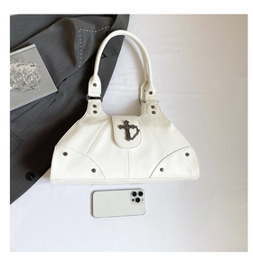 Detailed top view of a white leather handbag with metal cross and silver studs