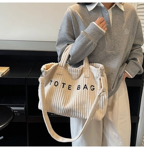 Detail of off-white corduroy tote bag showing large capacity and TOTE BAG lettering