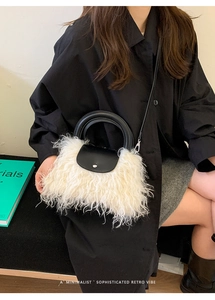 Detail of plush faux fur shoulder bag with black leather handle and metal clasp