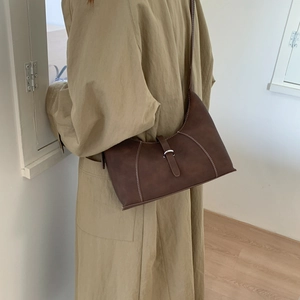 French minimalist dark brown leather underarm bag with contrast stitching and silver buckle