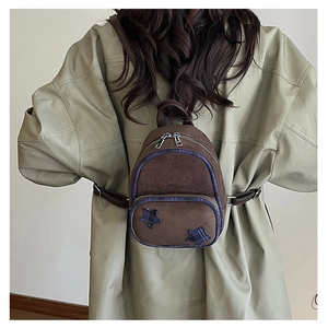 Dettaglio mini zaino scamosciato marrone con stelle a quadri blu e doppia cerniera lampo