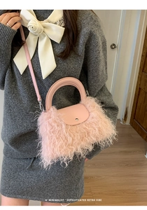 Detailed shot of a pink faux fur crossbody bag with fringe and silver metal snap closure