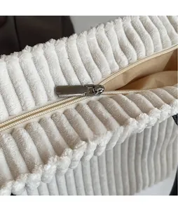 Detailed macro view of white corduroy tote bag showing smooth silver zipper and stitching