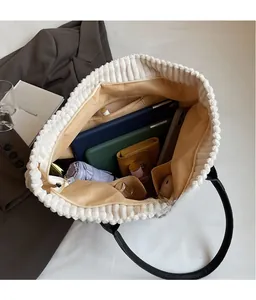 Spacious interior of corduroy tote bag holding tablet, umbrella and cosmetics