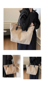 Detail of beige corduroy tote bag with black leather straps showing striped texture