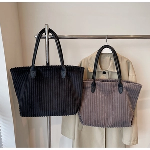 Detailed view of high-quality corduroy texture and faux leather straps on tote bags