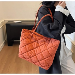 Detail shot of orange quilted tote bag with diamond stitching and spacious design