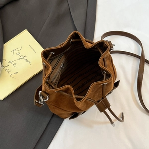 Deep brown suede drawstring bucket bag with striped lining and slim leather strap