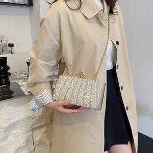 Elegante Perlen Clutch Tasche mit Goldkette und Straßstreifen in einem modernen Café