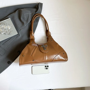 Retro brown leather handbag with metal cross and rivets shown with smartphone for scale